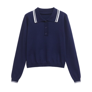 Détail du polo bleu marine en maille avec rayures blanches au col et aux poignets