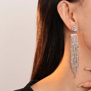 Close-up of elegant long tassel diamond earrings with sparkling cubic zirconia on model
