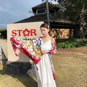 Ethnic style summer beach shawl with colorful patterns and tassels on a white dress