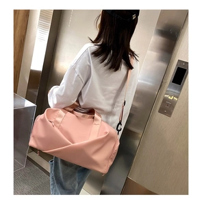 Sac de fitness en nylon rose avec bandoulière réglable présenté dans un ascenseur