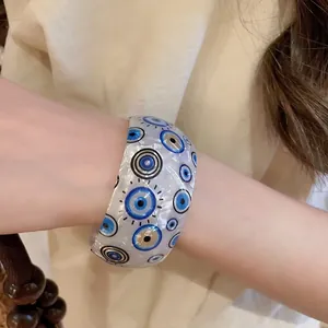Iridescent acrylic evil eye open bangle with a pearlescent finish for a unique style