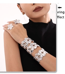 Wearing effect of silver flower bracelet and matching rings on a fashion model
