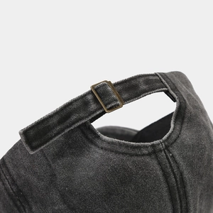 Adjustable bronze buckle on washed grey denim baseball cap with premium stitching detail