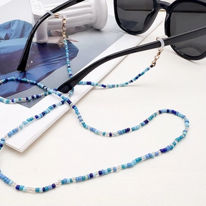 Detailed view of blue and white beaded lanyard with golden lobster clasps and rubber loops