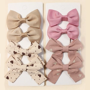 Detail view of 8-piece striped bow hair clips set on display cards for girls