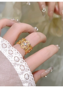 Gros plan d'une bague fleur évidée en plaqué or avec zircon sur la main du mannequin