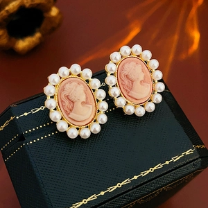 Détail de boucles d'oreilles camée vintage avec portrait et bordure de perles