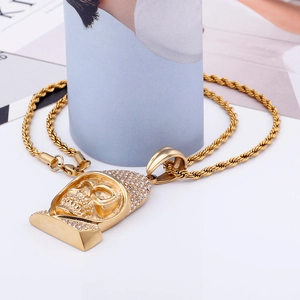 Detailed close-up of a golden skull pendant necklace with sparkling rhinestone inlay