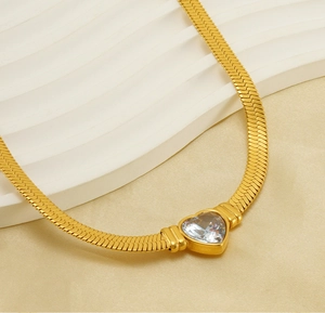 Close-up of 18K gold plated heart pendant with zircon on a flat snake bone chain