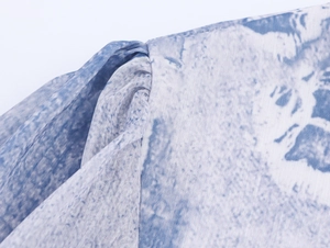 Détail du tissu en mousseline tie-dye bleu et blanc avec couture plissée à l'épaule