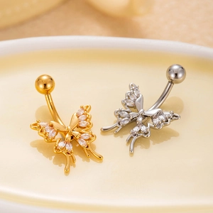 Macro shot of gold and silver heart butterfly navel rings with micro-set zircon stones