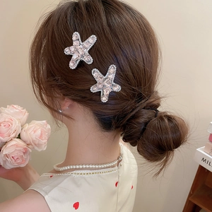 Detailed close-up of pink crystal star hair clips worn on side hair for a sweet look