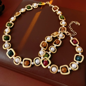 Détail d'un collier doré vintage avec perles et pierres précieuses sur cuir sombre