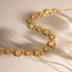 Makroaufnahme von 18K Gold Gänseblümchen Schmuckset mit gebürsteter Metallstruktur und Zirkon