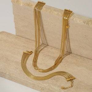 Macro detail of gold-plated multi-layer tassel necklace and bracelet jewelry set