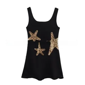 Close-up of black sleeveless mini dress featuring gold sequin star embroidery details