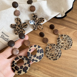 Macro view of leopard print resin flower earrings with wooden beads in bohemian style