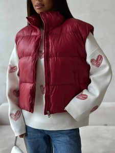 Detail of red quilted vest over heart pattern knit sweater with stand collar design