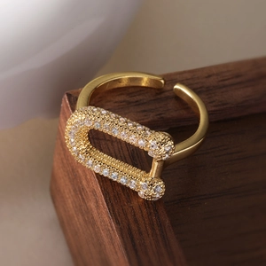 Elegant 18K gold plated U-shaped open ring with cubic zirconia on dark wood background