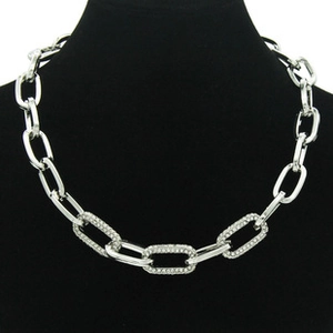 Detailed view of silver thick link necklace with sparkling rhinestones on black mannequin