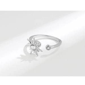 Detailed macro view of an adjustable sun-shaped stress relief ring with white gemstone inlay