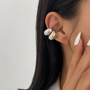 Detail view of a silver minimalist multi-layer ear cuff on a female model