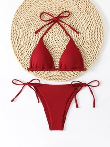 Deep red ribbed triangle bikini set with halter top and side-tie bottoms on straw mat