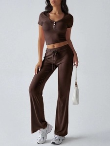 Dettaglio del set due pezzi in maglia a coste marrone con crop top e pantaloni svasati