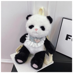 Detail of soft plush panda backpack with a blue bow tie sitting on stacked books