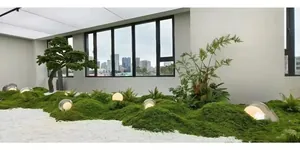 Detailed indoor micro landscape featuring artificial moss, white pebbles, and warm globe lights