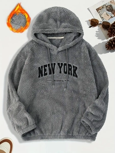 Dettaglio felpa con cappuccio in pile grigio con ricamo New York e trama morbida