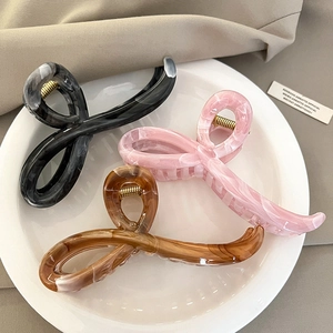 Three-piece acrylic hair claw set in black ink, marble pink, and amber brown colors