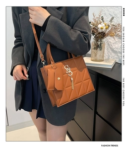 Detail of brown quilted PU leather shoulder bag with gold hardware and small pouch