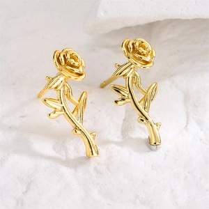 Pendientes minimalistas de cobre bañados en oro de 18K con rosa sobre fondo de piedra