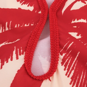 Hawaiian palm leaf print dress with red braided trim and soft fabric texture details