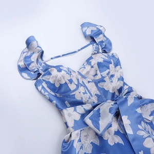 Detail of blue floral satin dress featuring ruffled straps and a waist bow decoration