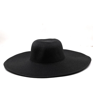 Close-up of the detailed woven texture on the wide brim of a black straw sun hat