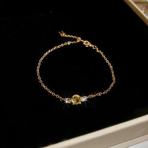 Close-up of zircon flower pearl bracelet with gold chain on black velvet background