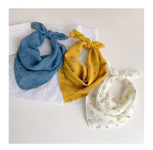 Three-pack of soft cotton gauze baby bibs in blue, yellow, and cream with smile prints