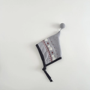 Close-up of baby knit hat featuring elk jacquard patterns and top soft pompom detail
