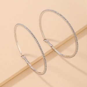 Macro shot of silver hoops with inlaid crystals and a secure snap-lock closure