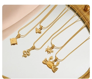 Detailed view of five gold-plated necklaces with unique animal pendants on a mirror