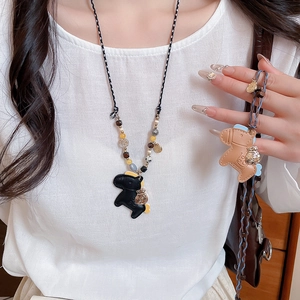 Close-up of model wearing acrylic stone beaded leather horse pendant necklace