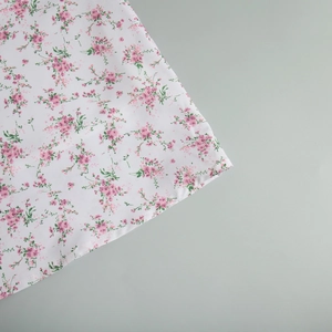 Dettaglio della stampa floreale rosa su tessuto bianco con cuciture di alta qualità