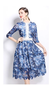 Detailed close-up of blue water-soluble lace and white scalloped crochet trim on dress