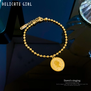 Macro detail of gold bead chain bracelet featuring 1998 Australian coin pendant and S.STEEL stamp