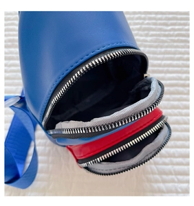 Close-up of children's blue and red crossbody bag with dual silver zipper compartments