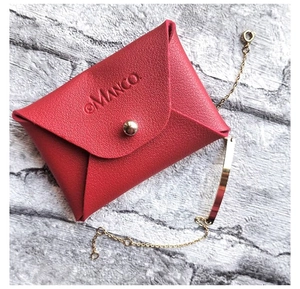 Nahaufnahme der roten Schmucktasche aus Leder mit goldenem Druckknopf und Logo-Prägung