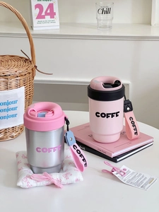 Detail view of pink and silver stainless steel coffee tumblers with woven carry handles
