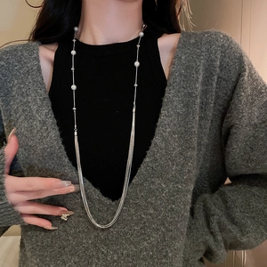 Elegant layered pearl necklace with silver chains draped gracefully on a model